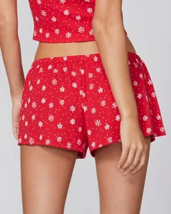 Close-up back view of red festive pajama set with white snowflake patterns and lace trim