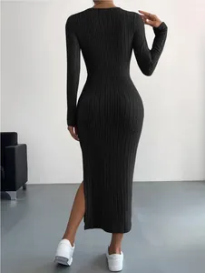 Vista trasera de un vestido de punto negro de manga larga con textura de canalé y abertura lateral