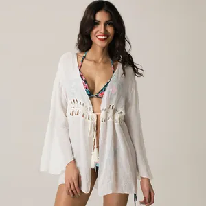 Vista frontale del cardigan da spiaggia bianco con patchwork di pizzo e lacci con nappine