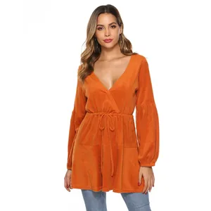 Detail of orange velvet top featuring deep V-neck, drawstring waist and lantern sleeves