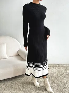 Détail d'une robe en maille noire avec ourlet plissé à rayures noires et blanches chic