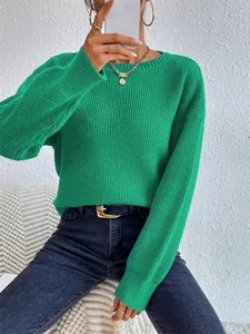 Dettaglio di un maglione in maglia verde vivace con trama a coste verticali e maniche lunghe