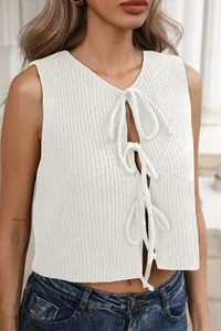 Dettaglio gilet in maglia bianca con triplo fiocco frontale e texture a costine sottili
