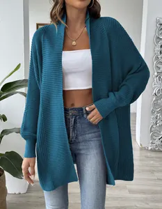 Detail der groben Strickstruktur und lockeren Passform der blauen Strickjacke am Model