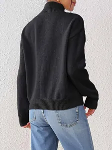 Rear view of women's black high-neck knit sweater featuring ribbed cuffs and hem detail