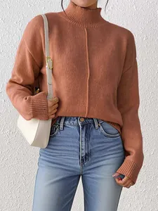 Detail of terracotta mock neck knit sweater showing ribbed cuffs and drop shoulder texture