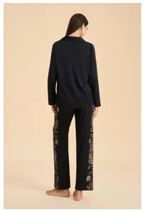 Back view of black satin loungewear set featuring floral print details on pant sides