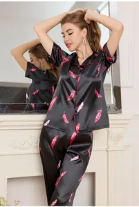 Detail of premium ice silk pajama set with red feather print and piping on black satin