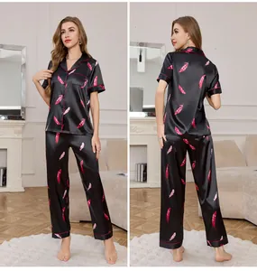 Detail of black silk pajama set with pink feather prints and elegant piped trim edges