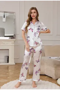 Detailed view of women's silk pajamas featuring pink butterfly prints and purple piping