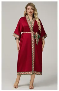 Detail of burgundy satin robe featuring intricate vintage gold and green scroll patterns