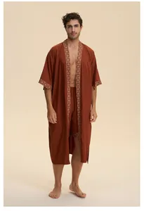 Dettaglio completo di vestaglia in raso rosso ruggine con bordo jacquard oro e shorts