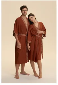 Elegante vestaglia in raso rosso mattone con bordo geometrico e dettaglio della cintura