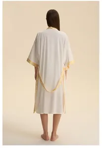 Dettaglio della vestaglia kimono con motivi floreali gialli su tessuto di raso crema