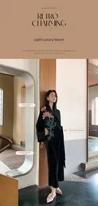 Detail of emerald green velvet robe with Chinese floral embroidery and tie-up placket