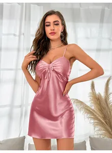 Detail of pink satin nightdress featuring a V-neckline with a delicate bow and silk texture