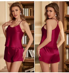 Detail of burgundy satin pajama set featuring camisole top and shorts in a home setting