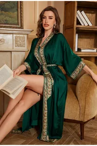 Detail of dark green satin robe featuring vintage gold baroque floral pattern on sleeves