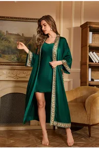 Close-up of elegant dark green satin robe with vintage patterned gold trim detail