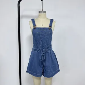 Detail of blue denim romper featuring adjustable metal buckles and a functional chest pocket