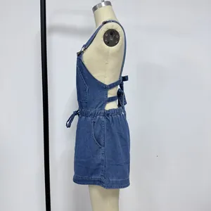Detail view of denim overall with adjustable metal buckles and elastic drawstring waist