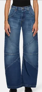 Détail du jean taille haute à jambes larges avec coutures patchwork et délavage bleu profond