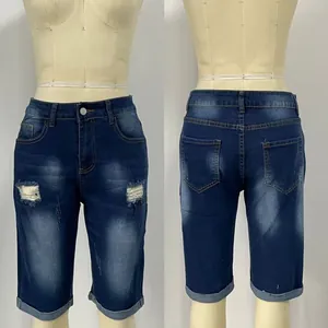 Front and back view of distressed dark blue denim shorts with ripped holes and cuffed hems