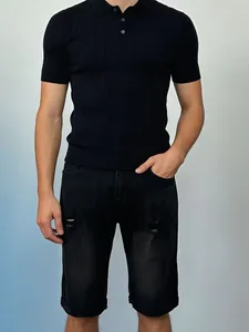Detail of men's black distressed denim shorts and rib-knit polo shirt close-up
