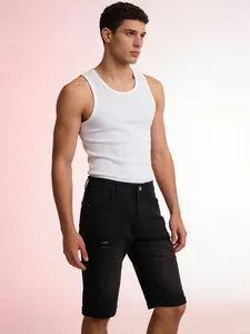 Detail of men's slim black denim shorts with ripped effects and cuffed hem styling