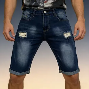 Detailed close-up of distressed denim shorts with ripped holes and folded hems