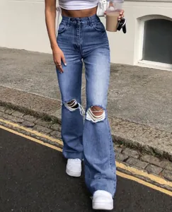 Close-up of high-waisted blue flare jeans featuring distressed ripped knee details