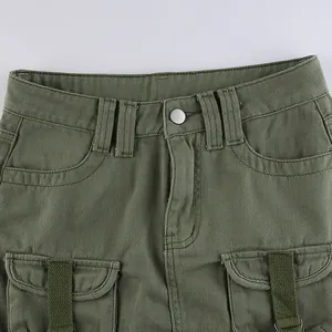 Detail of army green cargo skirt featuring cotton twill texture and webbed pockets