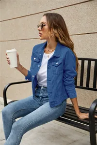 Detail of royal blue denim jacket featuring classic lapel collar and metal buttons