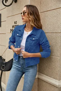 Detailed close-up of dark blue denim jacket texture with button-down flap pockets