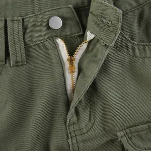 Detail of army green twill fabric with silver metal button and golden zipper closure