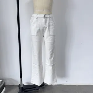 Dettaglio dei pantaloni bianchi a vita alta con cuciture a contrasto e tasche applicate