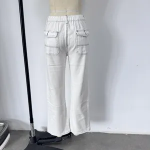 Dettaglio di pantaloni bianchi a vita alta con elastico e tasca posteriore impunturata