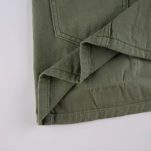 Detailed view of olive green twill cotton fabric with reinforced double-stitch hemline