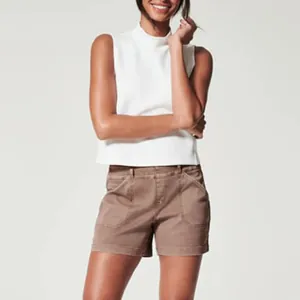 Detailed view of women's white sleeveless turtleneck top and brown casual summer shorts