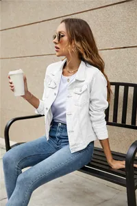 Detailed view of white denim jacket with classic lapel collar and flap pockets