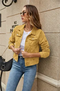 Detail of a slim fit mustard yellow denim jacket with classic lapel and buttoned pockets