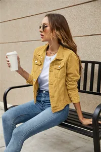 Detail of mustard yellow denim jacket featuring lapel collar and metal button pockets
