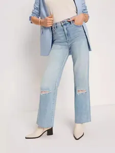 High-waisted straight leg jeans in light blue wash with ripped knees and raw hem edges