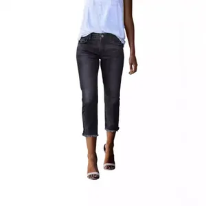 Close-up of women's washed dark grey cropped denim pants with stylish raw edge hem details