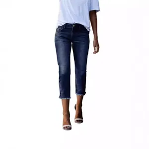 Detail of slim-fit cropped denim jeans in dark blue with frayed raw hem and washed finish