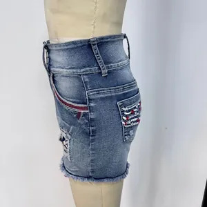 Détail d'un short en jean à taille haute avec broderie drapeau et rayure latérale rouge