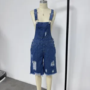 Close-up of distressed blue denim bib shorts with metal buckles and ripped details