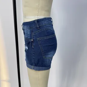 Dettaglio di pantaloncini di jeans blu scuro con effetto strappato e orlo risvoltato