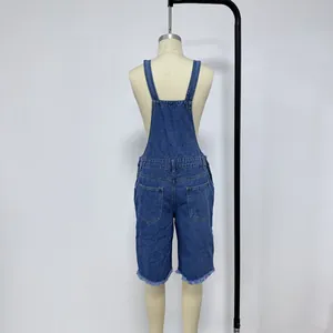 Rear view of distressed dark blue denim overalls shorts with frayed hem details