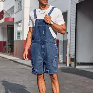 Close-up of distressed denim bib overalls with front pocket and metal buckles